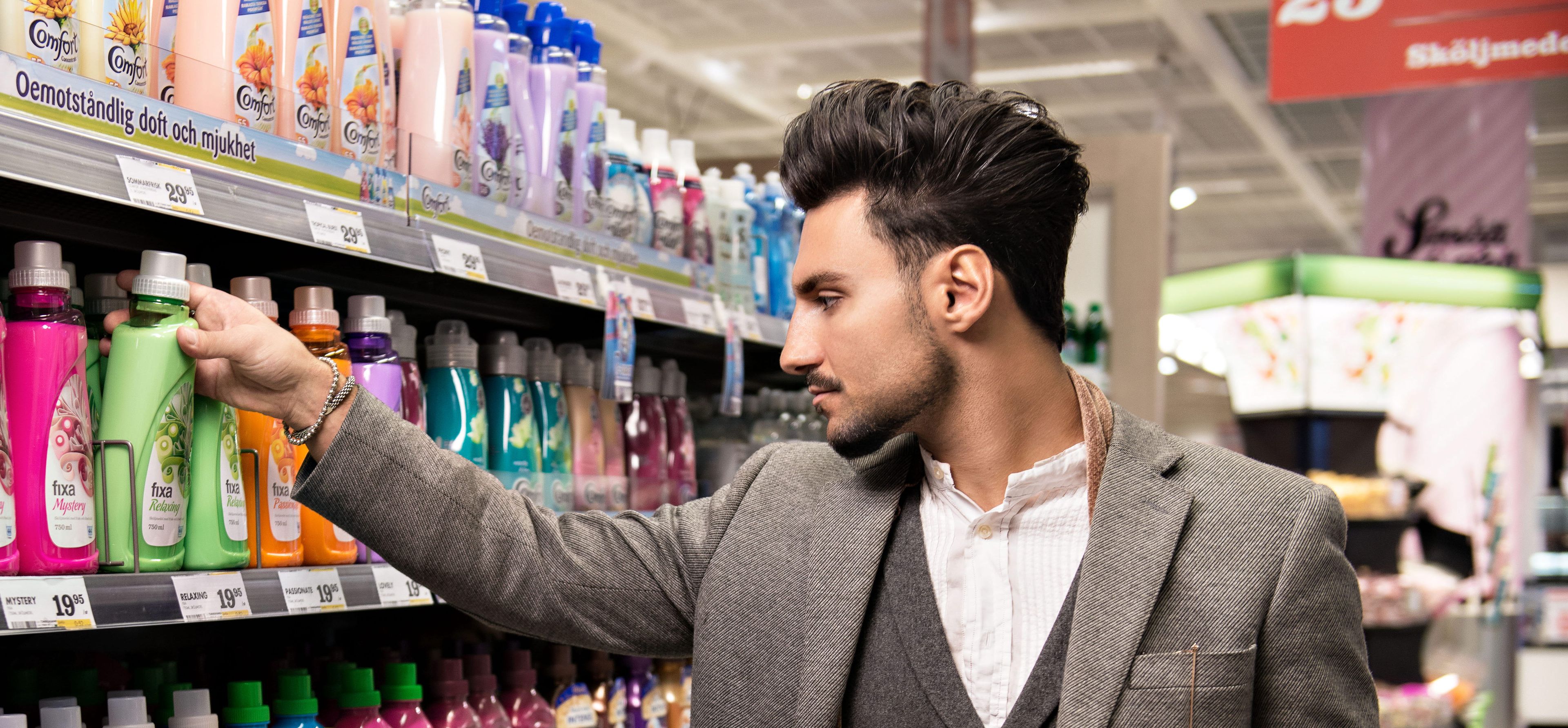Man looking at softner bottle in a store