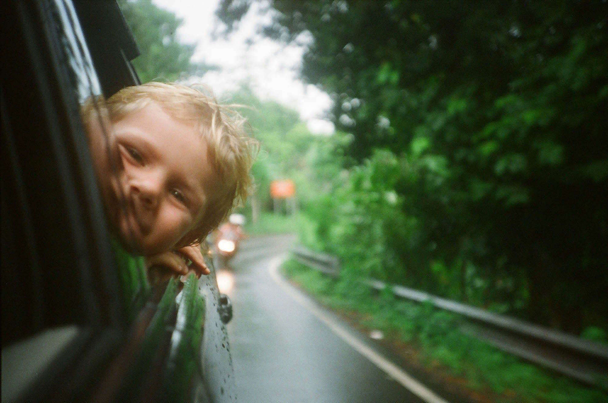 Child with head outside a car window
